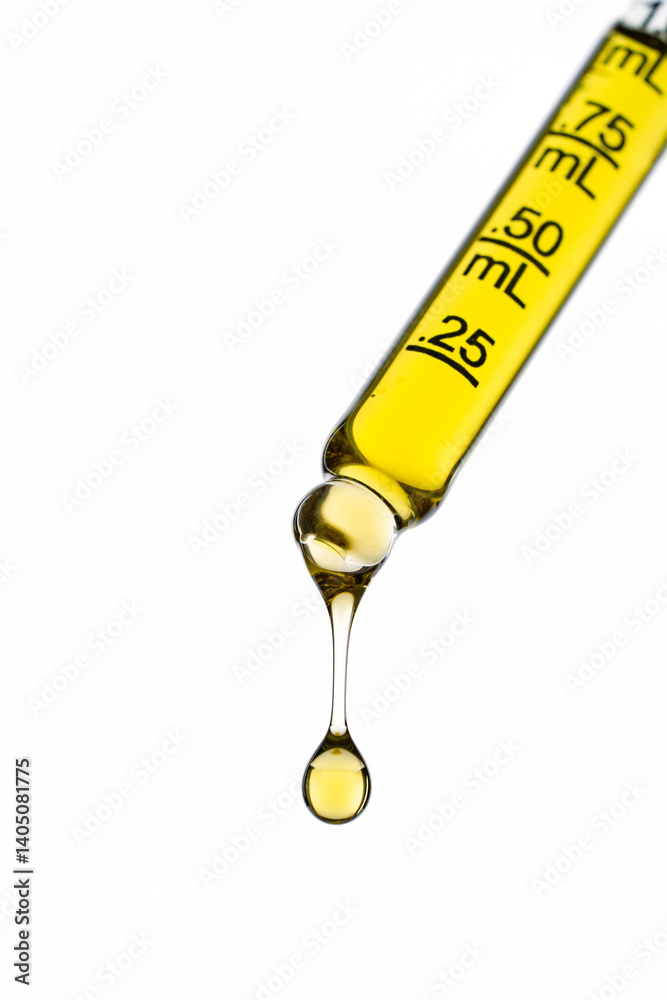 Yellow liquid in dropper on white background