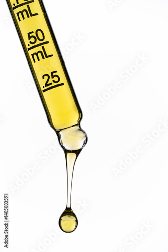 Yellow liquid in dropper on white background	
