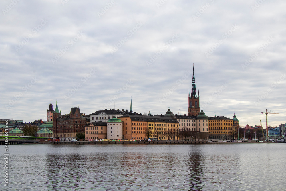 Historic Waterfront View of Stockholm Old Town with Church Spire under Cloudy Sky Historic Waterfront View of Stockholm Old Town with Church Spire under Cloudy Sky
