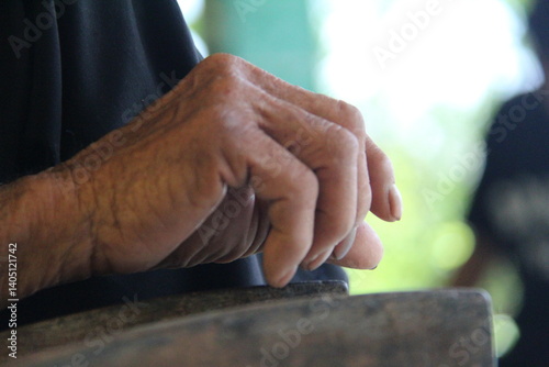 A close-up of an elderly person's wrinkled hand resting. Symbol of aging, experience, and the passage of time