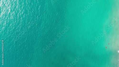 Pristine turquoise waters gently caressing sandy shoreline while kayaking tourists experiencing serene moment during tropical vacation adventure