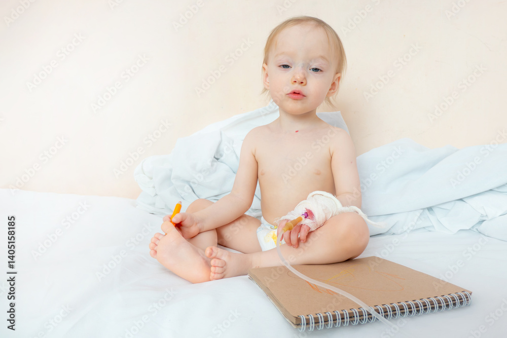 1,5 years old toddler girl painting or drawing by using color pencil at the hospital,Sick babysit on patien bed relax by painted on the sketch book. The concept of sublimation, art against pain and