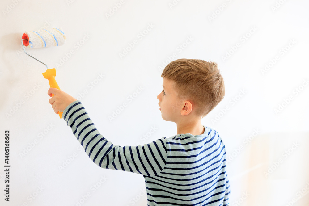 A young boy renovating a room, sanding the walls with sandpaper and painting them white with a roller. Home improvement and DIY repair concept A young boy renovating a room, sanding the walls with sandpaper and painting them white with a roller. Home improvement and DIY repair concept
