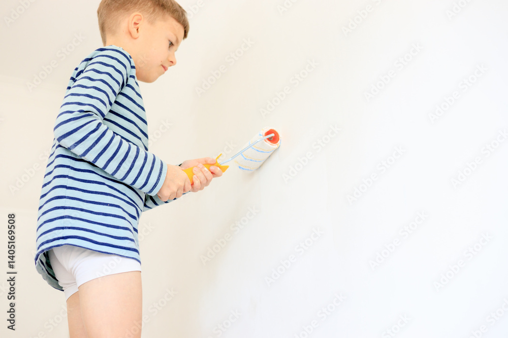 A young boy renovating a room, sanding the walls with sandpaper and painting them white with a roller. Home improvement and DIY repair concept