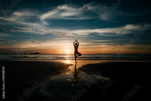 Obraz na płótnie The silhouette of a woman practicing yoga on a tropical beach at twilight in Thailand, embracing meditation and serenity. w salonie