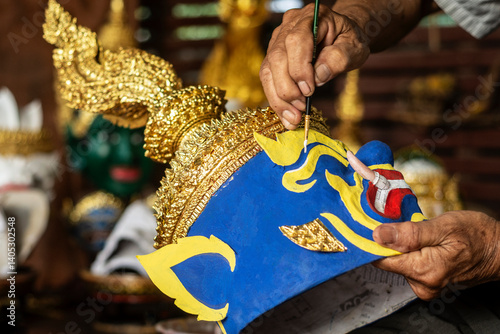 close up of artist painting lakhon khol traditional mask in cambodia photo