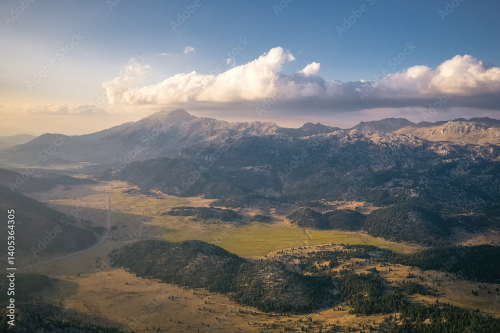 Sunny valley surrounded by mountains, sun shadows reflected on distant mountains. Exquisite natural scenery.