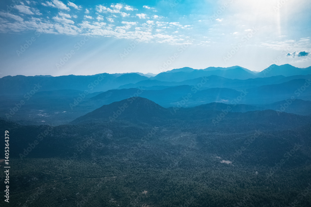Magnificent nature with mountains and forests. Beautiful sunny valley with blue sky in summer. Aerial view with drone.
