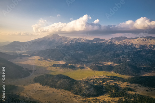 Obraz na płótnie Sunny valley surrounded by mountains, sun shadows reflected on distant mountains. Exquisite natural scenery. w salonie