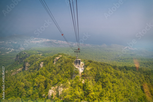 Obraz na płótnie Cable car moving down from the summit of Tahtali Mountain in Antalya province of Turkey. The cabin goes down. Lush forest view. w salonie
