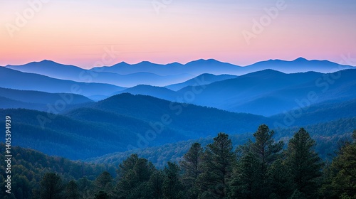 Misty mountain ranges painted in shades of blue at dawn.