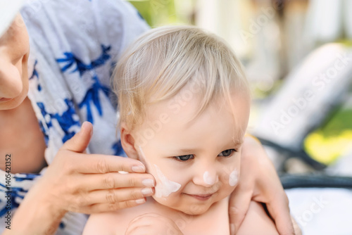 Wallpaper Mural Mother applying sunscreen protection creme on cute little toddler boy face. Mom using sunblocking lotion to protect baby from sun during summer sea vacation. Children healthcare at travel time Torontodigital.ca