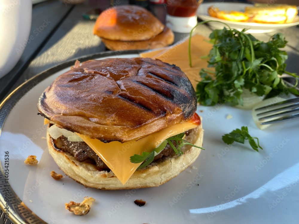 Selbstgemachter Hamburger Cheesebruger beim grillen