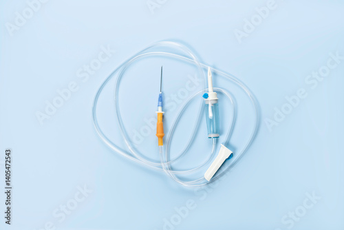 Hand dropper with sharp needle and tube regulator on blue background.