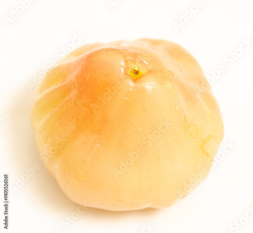A small, round, yellow fruit with a stem on top