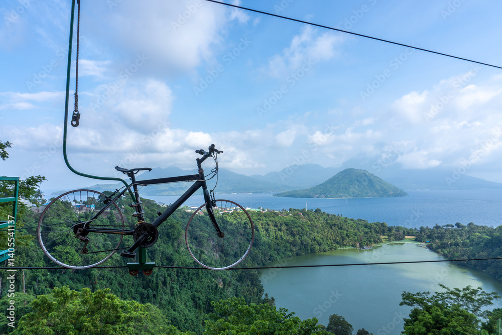 Naklejka premium Bike Hanging Overlooking Scenic Lake and Mountain Landscape on Summer Day