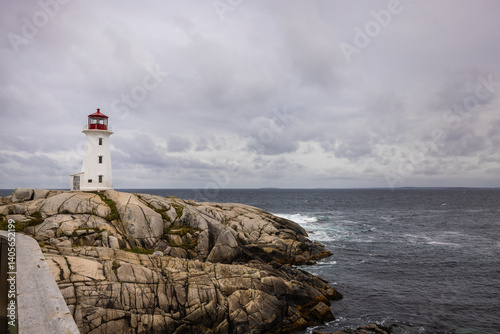 Image of red and white lighthouse on the coast of Peggy's Cove looking our onto Saint Margaret's Bay in Canada