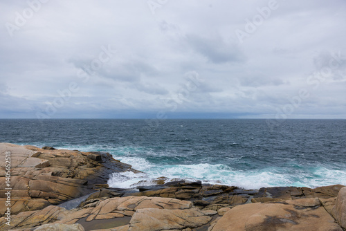 Rocky hard granite shoreline on Peggy's Cove Nova Scotia Canada waves crashing.