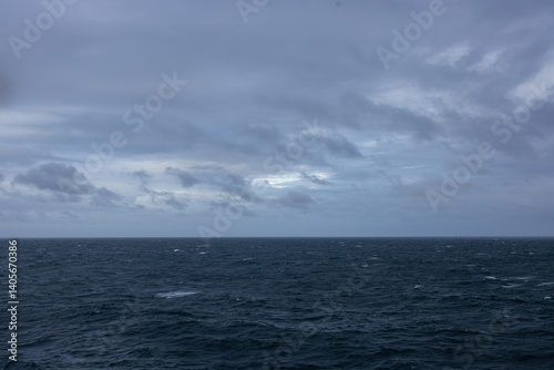 Overcast day open ocean on the horizon calm rippling wavy water surface.