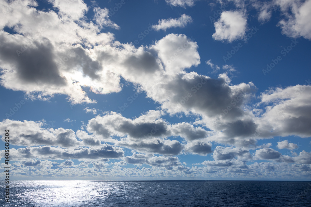 Obraz premium Beautiful open ocean on the horizon alluring bright sun lit cloudscape cumulus gray and white cloudy day.