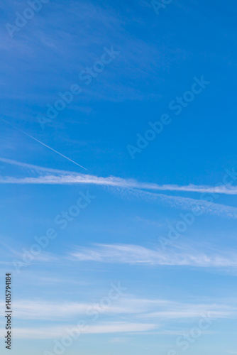 Clear Blue Sky with Contrails and Subtle Atmospheric Details