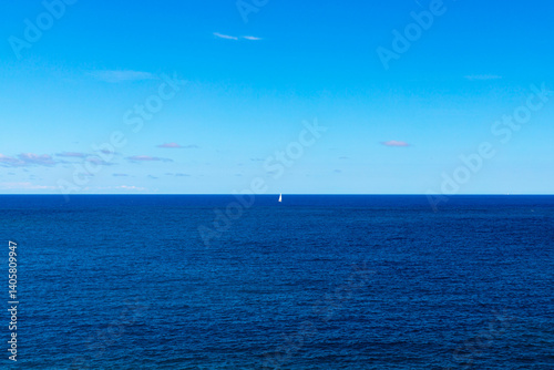 Obraz na płótnie Beautiful seascape of the Adriatic Sea with a sailboat barely visible in the distance w salonie