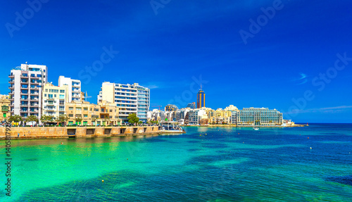 Obraz na płótnie Cityscape of St Julian's Bay on a sunny day with clear blue skies and turquoise water, Malta w salonie