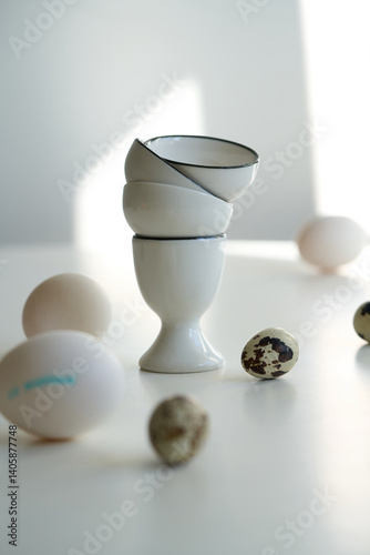 Chicken and quail eggs on a white table, modern Easter-themed still life.