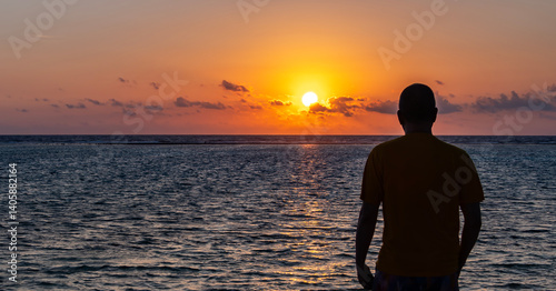 Obraz na płótnie Silhouette of a Man looking at a Beautiful Sunrise on a Tropical Beach w salonie