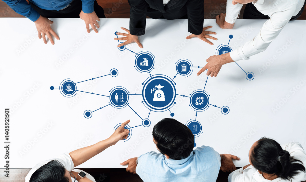 A business team collaborates around a table, analyzing strategic reduction strategies with icons representing financial goals and processes, highlighting teamwork and innovation. Amity