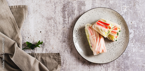 Obraz na płótnie Spring rolls with crab meat, cucumber and herbs on a plate on the table top view web banner w salonie