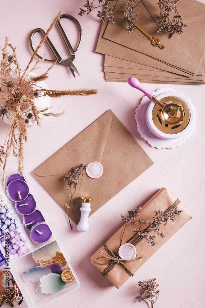 Craft envelope with wax seal and crafting items on pink top and vertical view