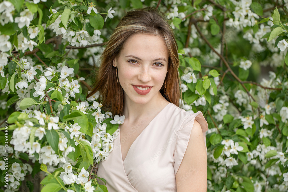 Young beautiful girl posing in a blooming garden Young beautiful girl posing in a blooming garden