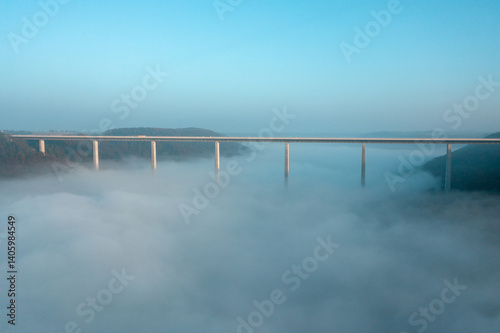 Germany's tallest bridge over dense fog, drone aerial view, at sunrise in Braunsbach, Germany