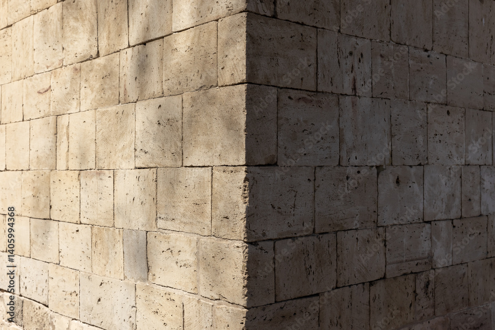 Photograph of the corner of a brick wall with stone blocks