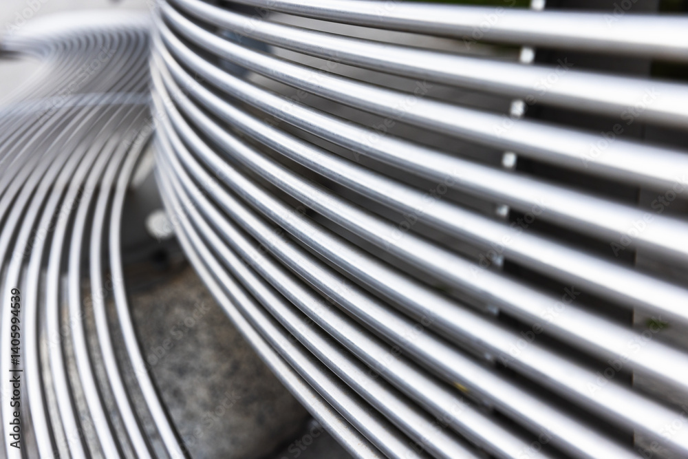 Close up photo of a metal bench featuring abstract curved striped lines