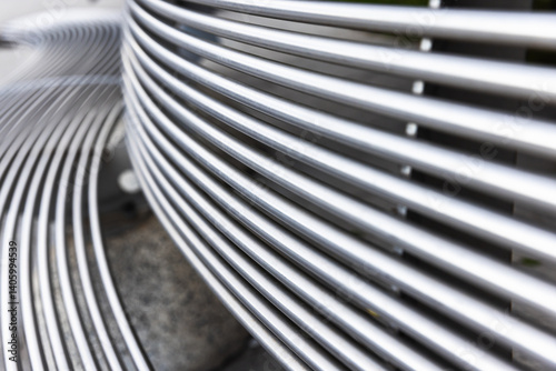 Obraz na płótnie Close up photo of a metal bench featuring abstract curved striped lines w salonie