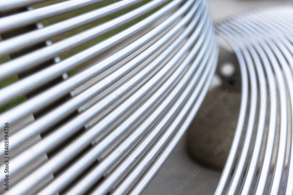 A detailed view of a metal bench featuring abstract curved striped lines