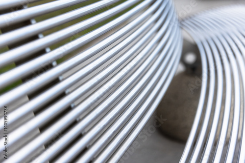 Obraz na płótnie A detailed view of a metal bench featuring abstract curved striped lines w salonie
