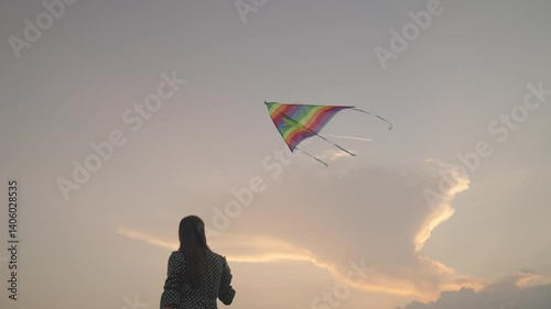 Free girl launches a kite into the sunset sky, have fun on the journey, play in the fun outdoors of nature, dream to fly, women's weekend with rainbow color play in nature, catch the wind high above.