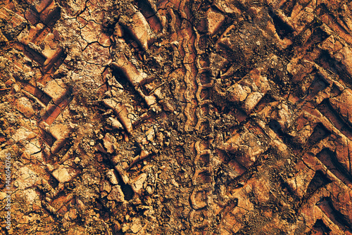 Tractor tire track imprint in dirt road dried muddy ground