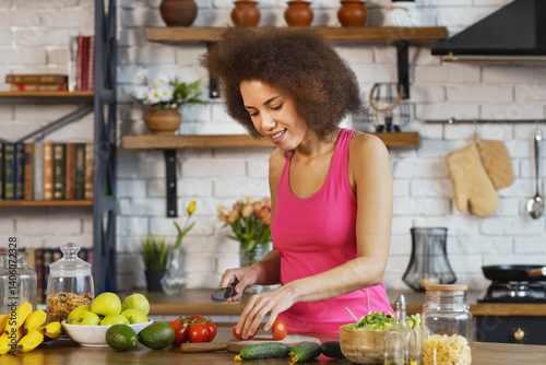 Obraz na płótnie Happy woman in top preparing healthy vegetable salad at home kitchen smiling and enjoying fresh organic ingredients for clean eating lifestyle w salonie