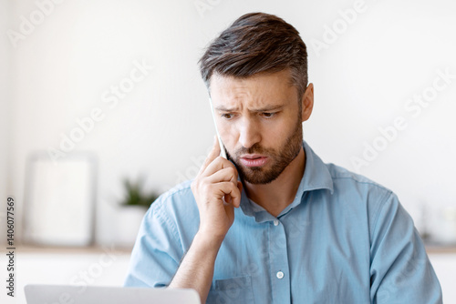 Worried Male Entrepreneur Having Problems With Laptop Computer At Work, Talking With Customer Support On Cellphone, Concerned Man Suffering Bad Internet Connection At Workplace In Office, Free Space