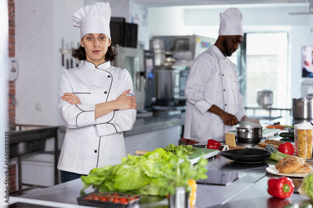 In a luxurious restaurant kitchen, female chef cooking tasty fine dining meals by preparing ingredients using stainless steel tools at the kitchen counter. Mastering food prep techniques.