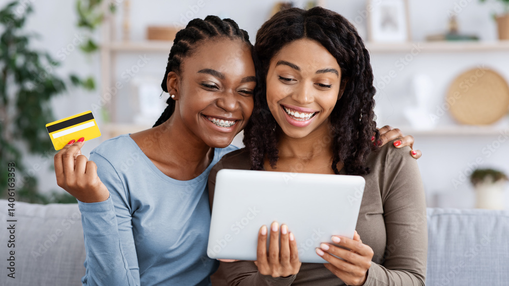 Happy black ladies shopping online, using digital tablet and credit card at home, closeup. Cheerful african american girlfriends buying stuff on internet, living room interior, copy space Happy black ladies shopping online, using digital tablet and credit card at home, closeup. Cheerful african american girlfriends buying stuff on internet, living room interior, copy space