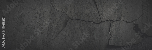 Obraz na płótnie Dark wide panoramic background. Peeling paint on a concrete wall. Faded dark texture of old cracked flaking paint. Weathered rough painted surface with patterns of cracks. Shaded background for design w salonie