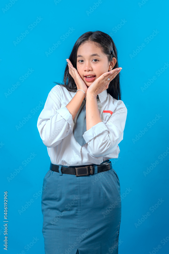 Cute Indonesian high school girl in uniform showing a surprised and cheerful expression with hands on cheeks. Her playful face and bright smile create a fun, youthful energy. Cute Indonesian high school girl in uniform showing a surprised and cheerful expression with hands on cheeks. Her playful face and bright smile create a fun, youthful energy.