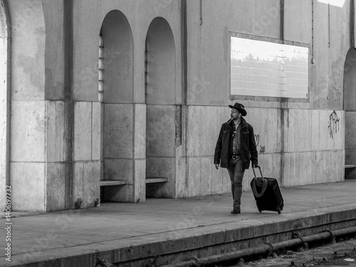 45 year old European white man with style. Move a suitcase with trolleybus in old train station.