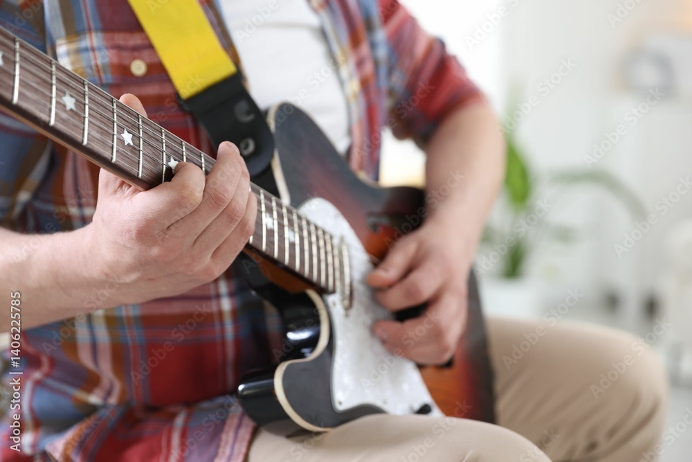 Obraz premium Man playing guitar at home, focus on hand