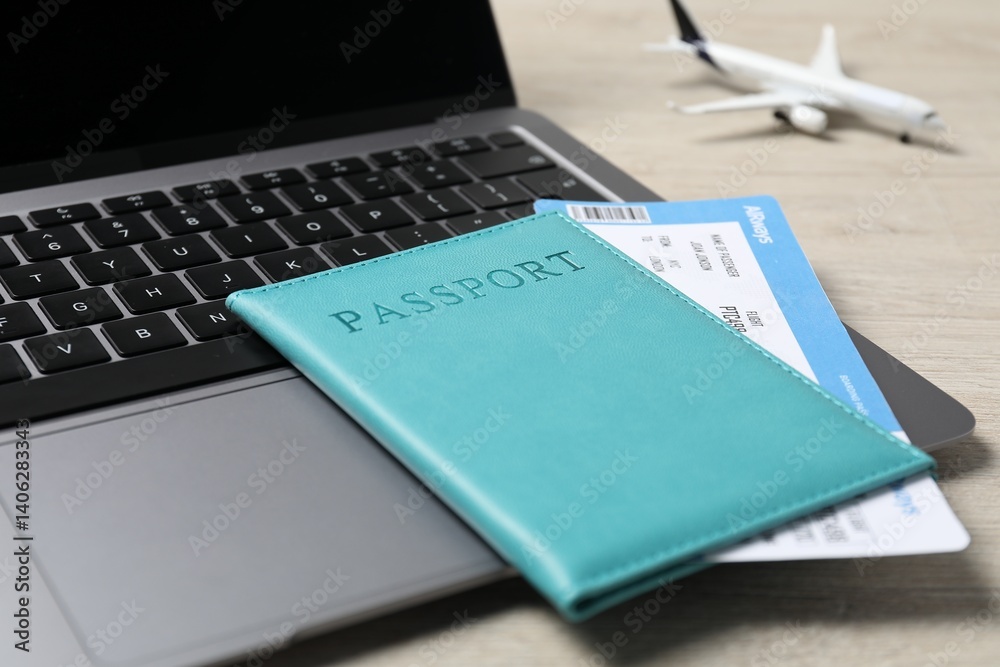 Passport, flight ticket, plane model and laptop on wooden table, closeup Passport, flight ticket, plane model and laptop on wooden table, closeup